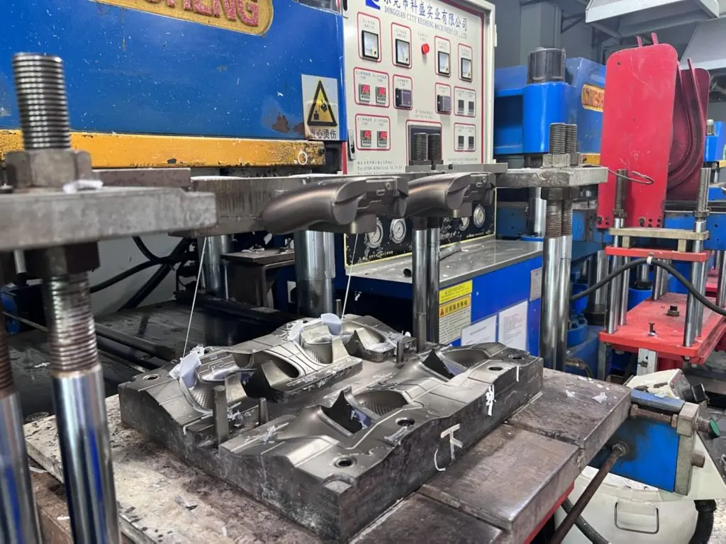 Rubber compression molding press with custom mold, industrial silicone and rubber part manufacturing