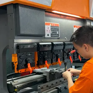 A worker operating a CNC bending machine to fabricate metal parts with high precision, essential for industries like automotive, aerospace, and manufacturing.